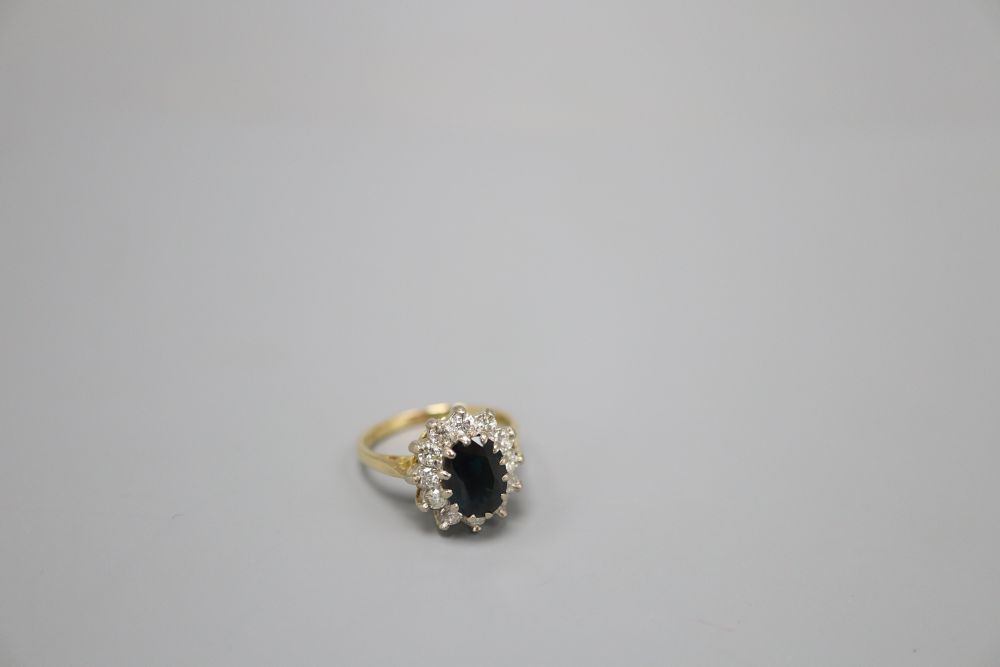 An 18ct gold sapphire and diamond oval cluster ring, size J